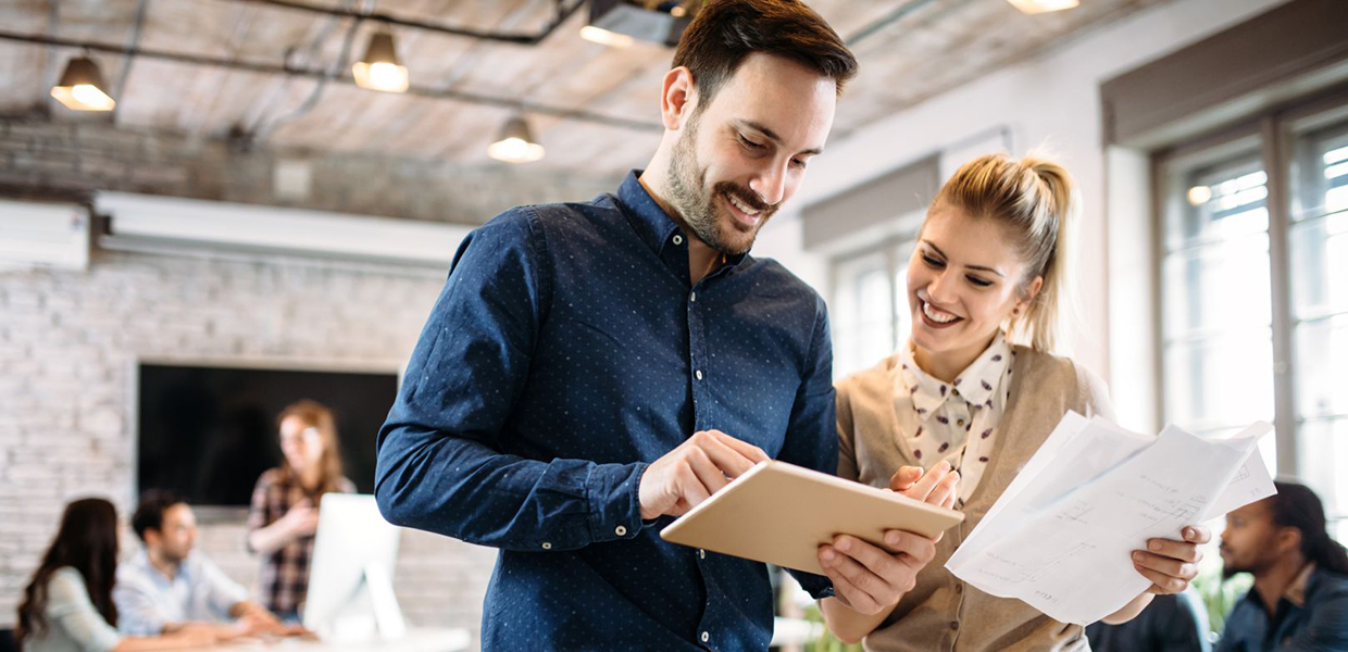 photo of a man and a woman looking at a tablet